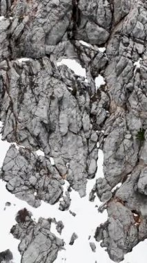 Türk dağlarının sinematik zevkini yaşayın. Bu dikey videoda kıvrılan bir nehir ve pitoresk şelalenin yer aldığı kış manzarasının havadan görüntüsünü deneyimleyin..