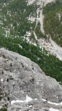 Türk dağlarının büyüleyici kış harikalar diyarını keşfedin, bu dikey videoda yer alan kıvrımlı bir nehir ve manzaralı şelalelerin yer aldığı.