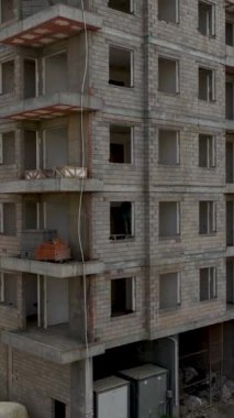 Hareketli inşaat faaliyetlerinin üzerinde süzül ve bu dikey videoda inşaatçılar işlerini yaparken yükleri boşaltan bir vincin havadan görüntüsünü yakala..