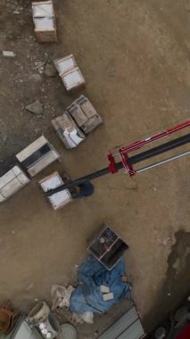 Bir vinç kargoyu indirirken ve inşaatçılar dikey videoda havadan çekilen görevlerinde ilerleme kaydederken, bir inşaat alanının mucizelerine hayret ediyorlar..