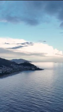 Bulutlu Akdeniz kıyı şeridinin zarif güzelliğine kapıl, sakin okyanus dokuları bu dikey videoda sakin bir atmosfer yaratıyor..