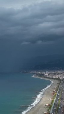Bu dikey videoda, fırtınanın ortasında güzel Akdeniz kıyı şeridinin ve şehir manzarasının uyanıklığını keşfedin..