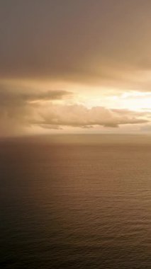 Bulutlu havalarda gün batımının gerçeküstü güzelliğiyle aydınlanan gökyüzüne bakın. Bu dikey videoda duyuları büyüleyen mistik desenler sergiliyor..