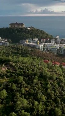 Hava manzarasının ihtişamını tecrübe edin. Muhteşem evler ve sakin bir şehirde havuzları olan villa kompleksleri bu dikey videoda büyüleyici bir görsel gösteri sunuyor.