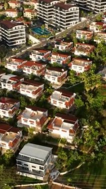 Şehir manzarasının farklı perspektiflerini incelerken iyi döşenmiş evleri ve havuzlu villa komplekslerini gözlemleyin, bu dikey videoda yukarıdan gelen lüks yaşam örneğini yakalayın..