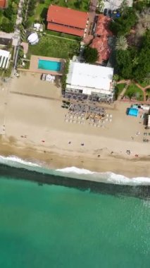 Büyüleyici Akdeniz kıyısına kurulmuş bir sahil kafesinin zarafetine hayret ederek bu dikey videoda sahil cazibesinin özünü yakalıyor..