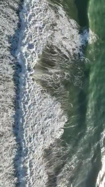 強力な波が絶え間なくクラッシュし 木製の桟橋を破壊するとして朝の嵐の怒りを目撃し この垂直ビデオで幻想的な白い波の魅惑的なディスプレイを作成します — ストック動画