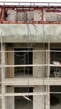 İnşaat alanlarının lüks apartmanlara dönüştüğü ve inşaatçıların projeyi belirli bir süre içinde tamamlama kararlılığını yansıttığı yukarıdan gelişen kentsel manzarayı keşfedin.