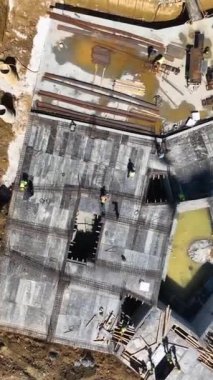 İHA devam eden çalışmaları incelerken, bu dikey videodaki ilerlemeyi ve aktiviteyi yakalayan açık inşaat alanının kuş bakışı görüntüsünü alın..