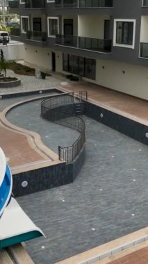 İHA yukarıda uçarken, bu büyüleyici dikey videoda çocukların kahkahalarını ve mutluluğunu yakalarken, konut kompleksindeki heyecan verici su kaymasının havadan görüntüsünü deneyimleyin..