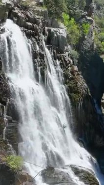Sihirli bir şelalenin görkemli güzelliğine şahit olun. Gökyüzü suyuyla sinematik çekimler yoluyla, bu büyüleyici dikey videoda cazibesini canlandırıyor..