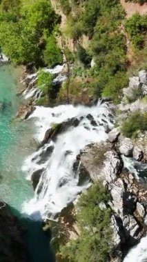 Canlı bir turistik bölgede çarpıcı bir şelalenin eşsiz güzelliğini keşfedin. Şelale gibi akan su seyircilerinizi büyülesin bu büyüleyici hava görüntülerinde...