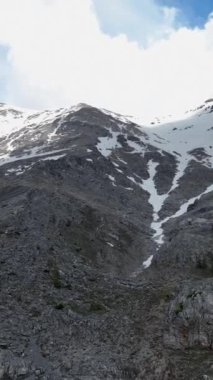 Seyircilerinizi görkemli dağların, karlı zirvelerin ve dramatik gökyüzünün büyüleyici hava görüntüleriyle harikalar dünyasına taşıyın. Bu çarpıcı görüntü ile dikey videonuzu geliştirin