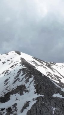 Karla kaplı zirvelerle övünen devasa dağların hayranlık uyandıran hava perspektifini tecrübe edin. Bırak dikey videonda doğanın güzelliği parlasın..