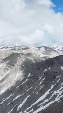 Sakin bir hava manzarasının dinginliğini keşfedin. Karlı zirvelerle bezenmiş görkemli bir dağ sırasını yakalayın. Seyircilerinizi dikey videonuzda doğanın sakin güzelliğine daldırın..