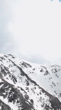 Karla kaplı zirveleri olan destansı dağ manzaralarının güzelliğini gösteren büyüleyici hava görüntüleriyle bir yolculuğa çıkın. Dikey videonuzu bu çarpıcı görüntülerle büyütün.