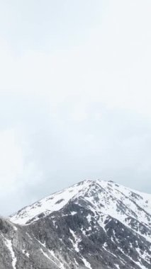 Karlı dağ vadisinin kış harikalar diyarına göz alıcı bir hava bakışından tanık olun. Karla kaplı manzaranın el değmemiş güzelliğinin dikey videonu yükseltmesine izin ver..