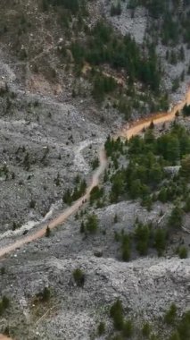 Dağlık bir cennetin dinginliğine geri çekiliyoruz. Karla kaplı tepeler ve dingin bir orman manzarası var. Manzaranın huzuru, dikey videonuzu geliştirsin..