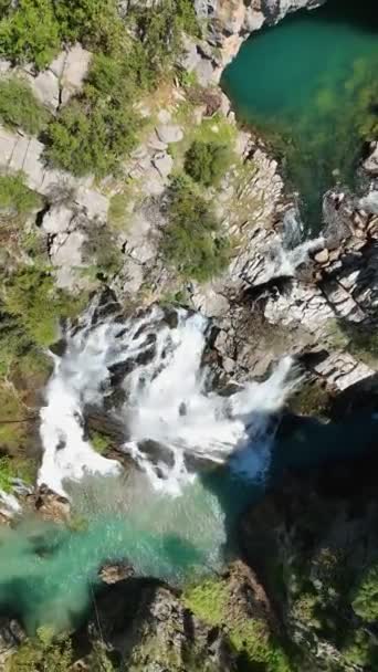 ドローンはこの魅惑的な垂直ビデオで魅惑的な空中の視点からその永遠の美しさをキャプチャするように紺碧の色合いと魔法の滝の神秘的な魅力に飛び込みます — ストック動画