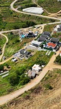 Bu büyüleyici hava gösterisinde prestijli villalar tarafından benimsenmiş bir yerleşim kompleksinin ahenkli karışımına tanık olun. Bu dikey video lüks yaşamın özünü vurgular..