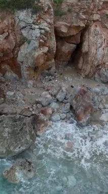 Kristal berrak suları ve kayalık kıyıları olan boş bir Akdeniz sahilinin hava güzelliğine bakın..