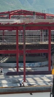 Malzemeler binanın üst katlarına yüklenirken büyük bir alışveriş merkezinin inşasına tanık olun..