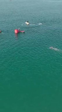 Gösteri Beleks triatlon yarışması sinematik olarak üstten başlıyor, yüzme, koşma ve bisiklet bölümlerini vurguluyor.