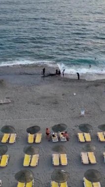 Akdeniz 'de su ve plaj şenliği dolu bir akşamın deniz kenarındaki alacakaranlık atmosferinin tadını çıkar..
