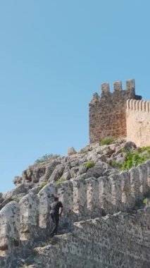 Yükselen bir maceraya atılın genç bir adam Alanyas kıyı kalesini keşfederken, yaz havasını kucaklayarak..