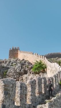 Genç bir adamın Alanya 'daki otantik bir kaledeki hedefine ulaşması ile yaz tırmanışına katılın..