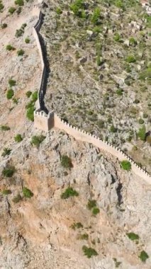 Türkiye, Alanya 'ya tepeden bakan antik bir kaleye tırmanan bir adam olarak bir kıyı macerasına atlayın..