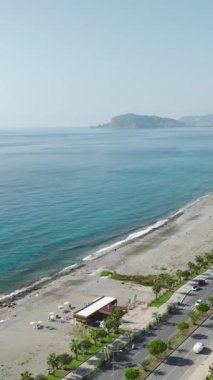 Akdeniz kıyısının güzelliğini keşfeden siyahlı bir adam gibi gökyüzü ufuklarını keşfedin..