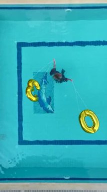 Bir manken olarak yaz cazibesini kucaklayın. Bu 4K hava manzaralı plaj toplarıyla havuza atlayarak su sıçratır..