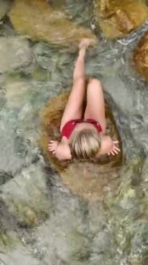 Kırmızı bikinili bir model olarak sükuneti keşfetmek bu 4K hava sahnesinde göktaşı gölünde teselli bulur..