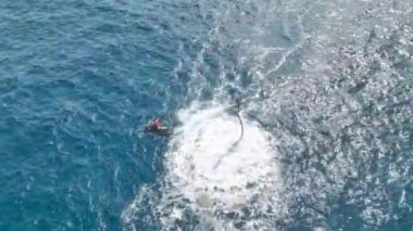 Bir kızın turkuaz Akdeniz dalgaları üzerinde gökyüzünde süzülüşünü izlerken bir uçan tahta fantezisinin canlanmasını izleyin. Hepsi 4K detaylarıyla..