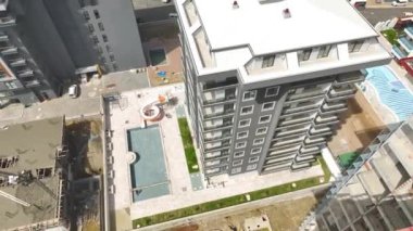 4K hava görüntüsü olan çok katlı bir binanın dış görünüşünü yakalayın. İnşaata yakından bak..