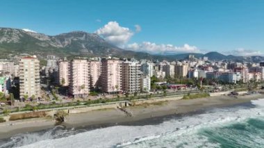 Gök mavisi sahil şeridindeki çarpıcı beyaz bir binanın 4K drone perspektifini izleyin. Büyüleyici hava görüntüleri.