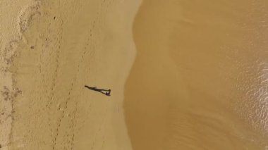 Akdeniz kıyısındaki altın plajın 4K insansız hava aracı görüntülerini izleyin. Güzel sahil boyunca yürüyen bir adam.