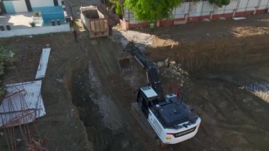 Kazı makineleri ve kamyonlar da dahil olmak üzere, inşaat sahasında toprakla çalışan 4K hava görüntülerini izleyin..