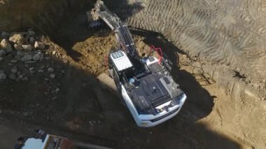 Kazı araçları ve inşaat alanında toprakla çalışan kamyonların 4K drone perspektifini izleyin. Büyüleyici hava görüntüleri.