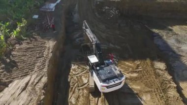 Toprakla çalışan kazıcılar ve kamyonlar da dahil olmak üzere ağır makinelerden oluşan 4K insansız hava aracı perspektifini izleyin. Büyüleyici..
