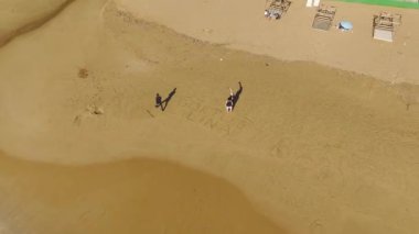 4K 'da Akdeniz' in kumlu sahillerinde yürüyen, siyah giyinmiş bir adamın huzur dolu yalnızlığını hissedin..