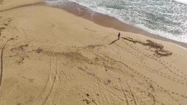 4K 'daki gök mavisi Akdeniz zeminine karşı siyahlı bir kumsalcının esrarengiz varlığını araştırın..