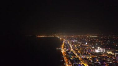 Gece şehrin canlanışına bakın. Parlak ışıklar binaları ve sokakları aydınlatıyor..