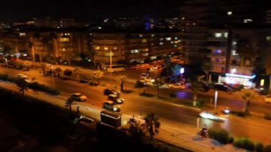 Parlayan binalar ve renkli neon ışıklarıyla parlayan şehir manzarasını izle.