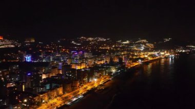 Renkli bina ışıkları ve hayat dolu yoğun yollarla dolu canlı bir gece şehrine bakın..