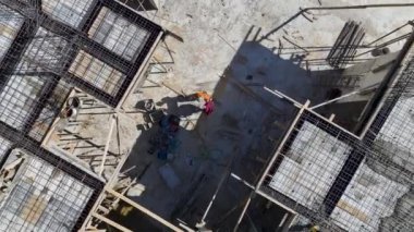 İnşaat ekibinin yeni bir proje sahasına beton döküp demiri şekillendirmek için çok çalıştığını gözlemleyin.