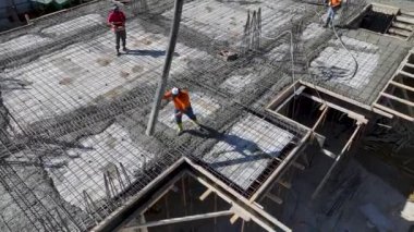 İşçiler demirleri bükerken ve beton dökerken inşaatın temellerini izleyin..