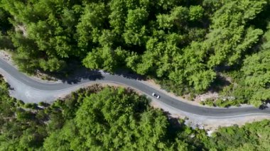 Panoramik manzaralı, heybetli dağ manzaralarında gezinen üstü açık bir araba görüyorsunuz..