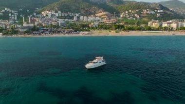 Akdeniz 'in berrak sularında manzaralı bir yolculukta beyaz bir yat izleyin..